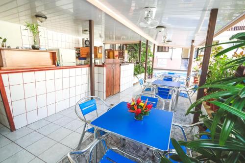 a restaurant with blue tables and chairs and plants at Hotel Flor Blanca in Manuel Antonio