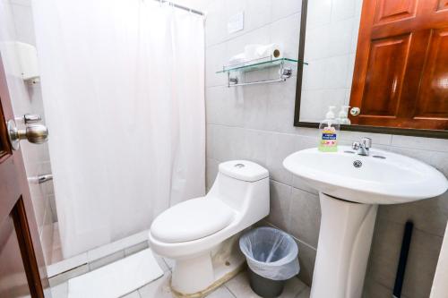 a bathroom with a white toilet and a sink at Hotel Flor Blanca in Manuel Antonio