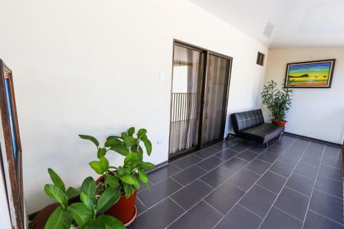 a hallway with a chair and plants in a room at Hotel Flor Blanca in Manuel Antonio