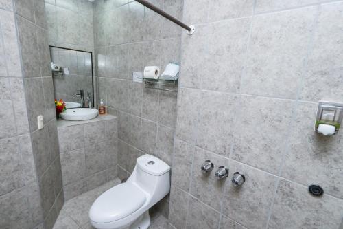 a bathroom with a toilet and a sink at Hotel Flor Blanca in Manuel Antonio