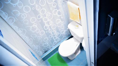 Un baño con inodoro y cortina de ducha. en Lima Limon Candelaria Hostel, en Bogotá