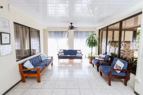 a living room with blue couches and a ceiling at Hotel Flor Blanca in Manuel Antonio
