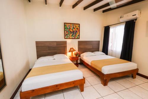 a bedroom with two beds and a window at Hotel Flor Blanca in Manuel Antonio