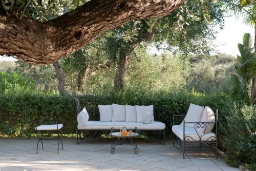 a white couch and two chairs on a patio at Tenuta Centoporte in Otranto