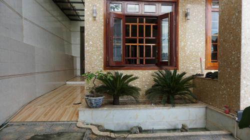 a building with two plants in front of a window at Duong Ha Hotel in Cao Bằng
