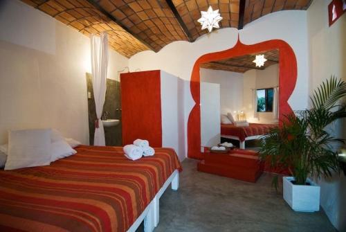 - une chambre avec un grand lit et une salle de bains dans l'établissement Petit Hotel Hafa, à Sayulita