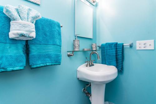 a blue bathroom with a sink and blue towels at Villa Serenity, Pet Friendly in Panama City Beach