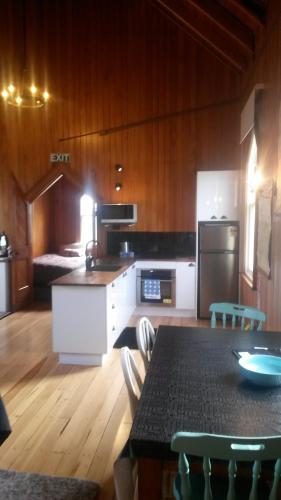 a kitchen with a table with chairs and a refrigerator at St Andrews Church Nave in Ophir