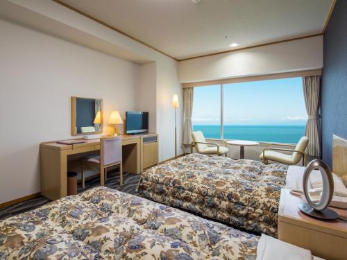 a hotel room with two beds and a desk at Hotel Ambia Shofukaku in Yaizu