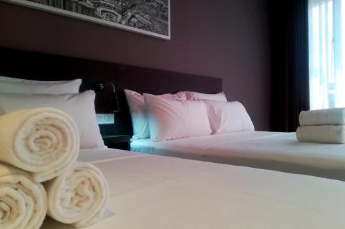 a bedroom with two beds with white sheets and pillows at The Loft Plaza Hotel in Bangi