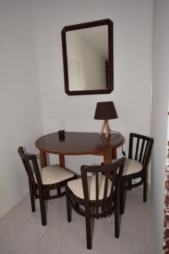 a table with two chairs and a mirror on a wall at Galotel Agnoudas near the airport in Markopoulo
