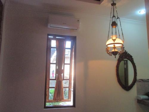 a chandelier and a window in a room at Rumah Ukhi Guest House in Yogyakarta