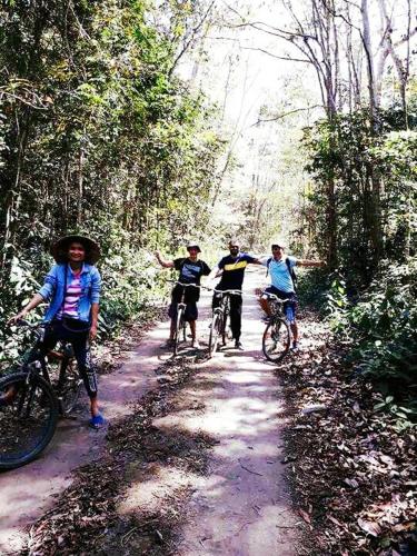 a group of people riding bikes on a dirt trail at Gibbon Singing Home Stay in Quan Tom