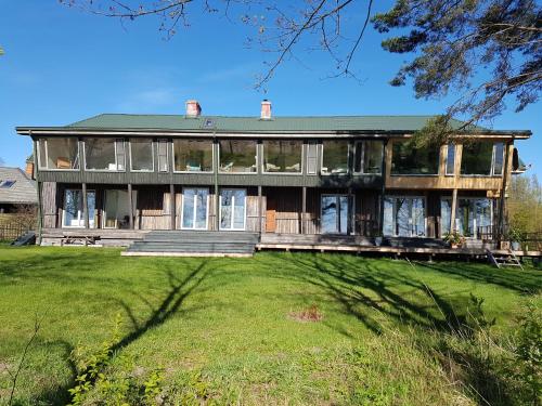 a large house with a large lawn in front of it at Guest House Vidlauči in Skulte