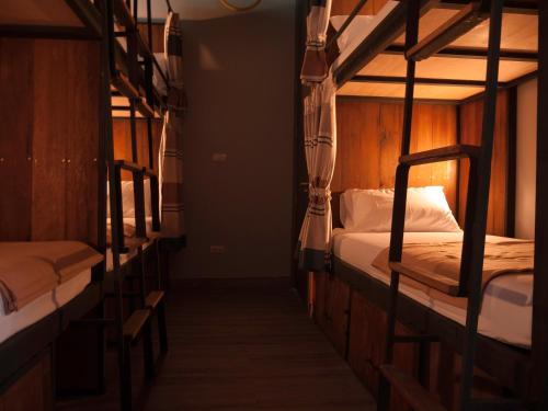 a room with three bunk beds in a room at Whereder Poshtel in Udon Thani