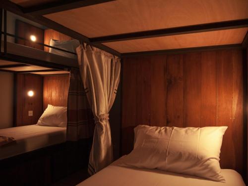 a bedroom with two beds and a bunk bed at Whereder Poshtel in Udon Thani
