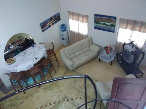 a living room with a couch and a table at Hillside Country Home in Santa Bárbara de Samaná