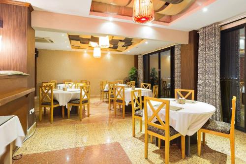 un restaurante con mesas y sillas en una habitación en Sunset Westlake Hanoi Hotel, en Hanói