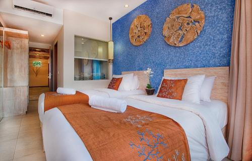 Dos camas en una habitación con paredes azules. en Natya Hotel Gili Trawangan, en Gili Trawangan