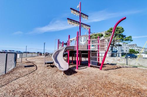 a playground with a slide in the sand at Getaway Oceanfront Lodging in Rockaway Beach