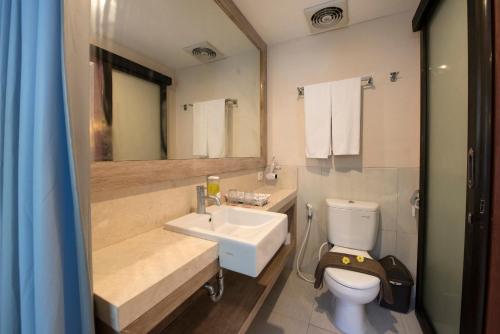 Un baño con lavabo, inodoro y espejo. en Natya Hotel Gili Trawangan, en Gili Trawangan