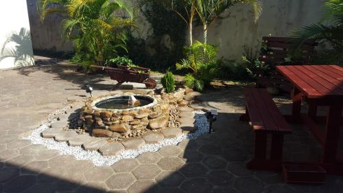 a fountain in a courtyard with benches and trees at The Homestead Margate - South Africa in Margate