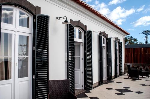 a row of shutters on a building with a patio at ARTS IN Hotel Conde Carvalhal in Funchal