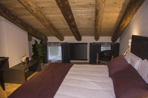 a bedroom with a large bed and wooden ceilings at Hotel Dal Menga in Torrebelvicino