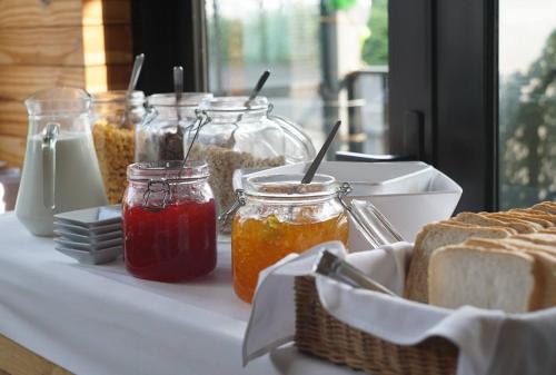 un tavolo ricoperto di barattoli di marmellata e pane di iSanook Hostel a Bangkok