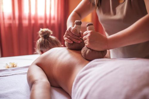 a man sitting on a bed getting his hair brushed at Almanity Hoi An Resort & Spa in Hoi An