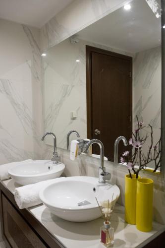 a white bathroom with two sinks and a mirror at Corali Resort in Agrinio