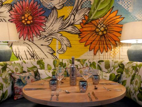 a table with glasses on it with a flower wall at HYDE Hotel in Galway