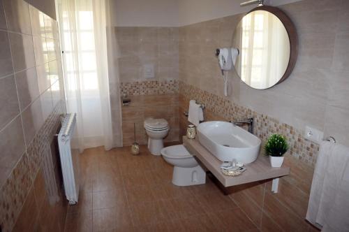 uma casa de banho com um lavatório, um WC e um espelho. em Antica Villa di Bruto em Tivoli