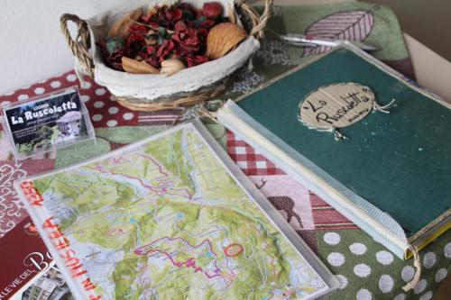 a table topped with books and a basket of food at Locanda La Ruscoletta in Telve