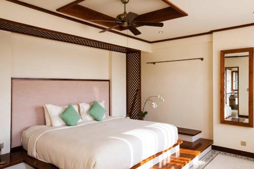a bedroom with a bed and a ceiling fan at Almanity Hoi An Resort & Spa in Hoi An
