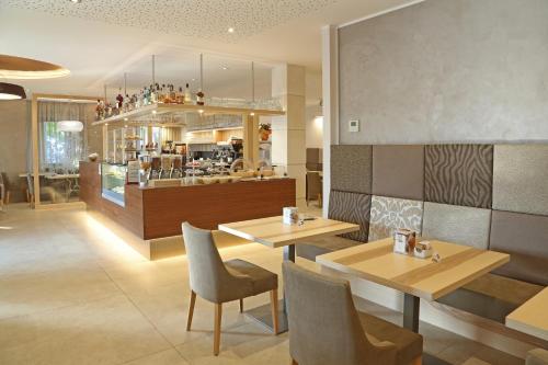un ristorante con due tavoli e sedie e un bancone di Hotel Garden a Peschiera del Garda