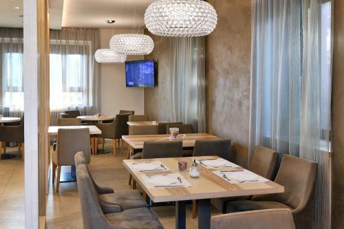 a restaurant with tables and chairs and a tv at Hotel Garden in Peschiera del Garda