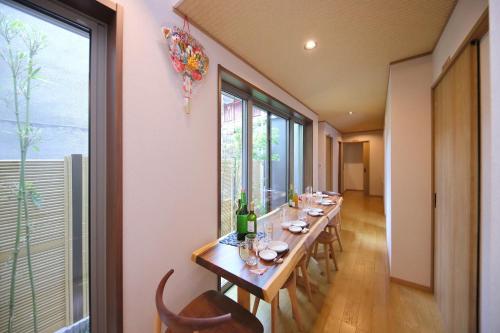 a long dining room with a long table with wine bottles at Kyo Machiya Ryokan Yuan in Kyoto