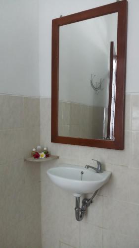 a bathroom with a white sink and a mirror at Villa Dencarik in Lovina