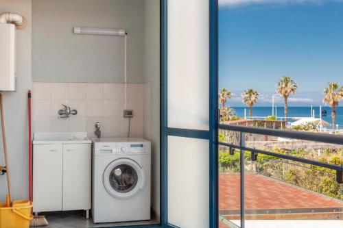 a washing machine in a bathroom with a view of the ocean at Terraces d'Orlando - Family Apartments with Sea View and Pool in Capo dʼOrlando