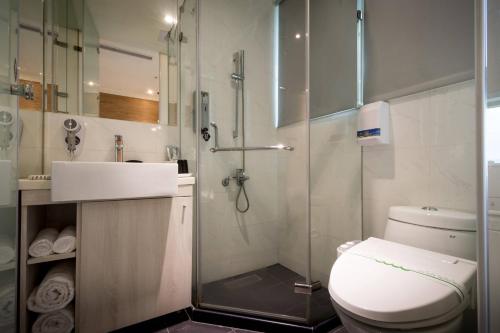 a bathroom with a shower and a toilet and a sink at Merryday Hotel Banqiao in Taipei