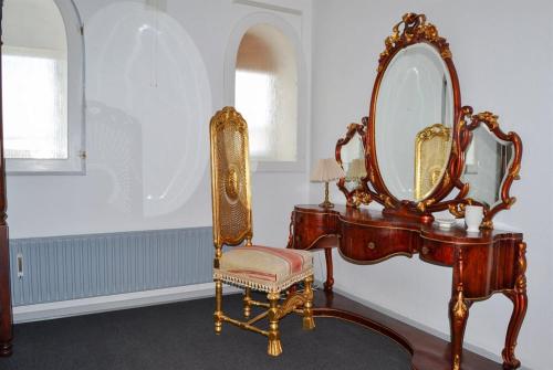 a dressing table with a mirror and a chair at Motel Lido in Bredebro