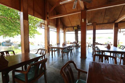 an empty restaurant with wooden tables and chairs at Marine Chaweng Beach Resort in Chaweng