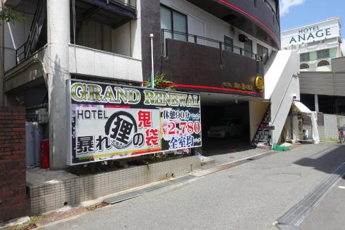 a sign on the side of a building at ホテル暴れ狸の鬼袋姫路駅前店 男塾ホテルグループ in Himeji