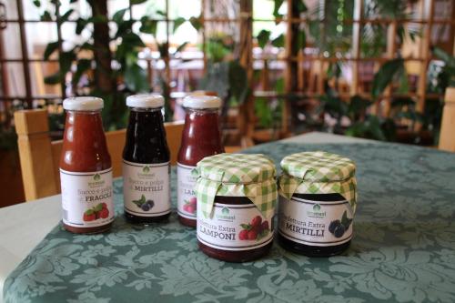 four bottles of ketchup and mustard sitting on a table at Locanda La Ruscoletta in Telve