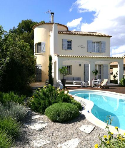 a villa with a swimming pool in front of a house at Bastide Philomen in Pérols