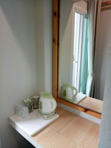 a bathroom with a sink and a mirror and a window at Baan Jaru in Chiang Rai