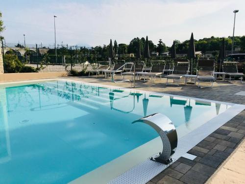 a swimming pool with chairs and chairs in a building at Aurora ApartHotel in Peschiera del Garda