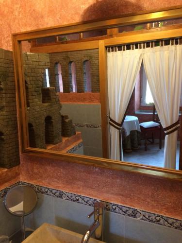 un bagno con specchio sopra un lavandino di Hotel Rural La Rosa de los Tiempos a Carneros