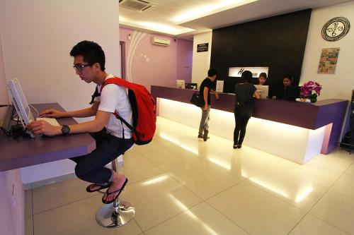 a man sitting on a ball in a waiting room at Here Hotel in Skudai